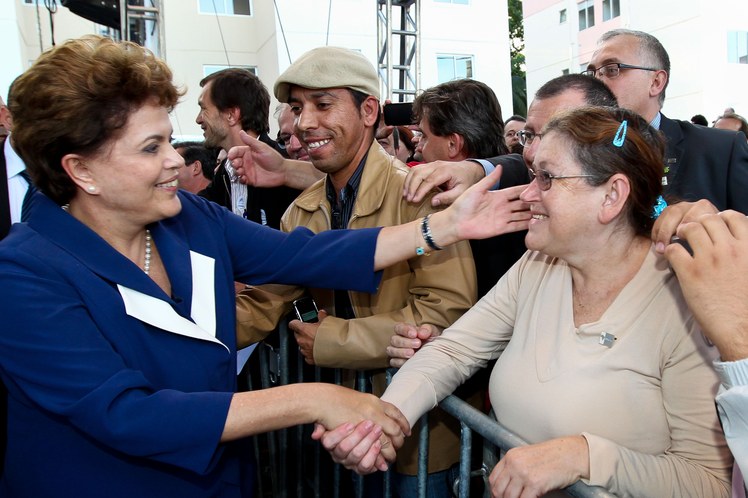 Dilma Rousseff cumprimenta o público presente à solenidade de entrega de unidades habitacionais 1