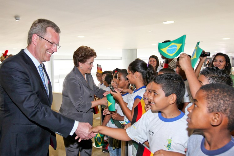 Presidenta Dilma Rousseff e o presidente da Alemanha, Christian Wulff, cumprimentam crianças na cerimônia oficial de chegada ao Brasil 2