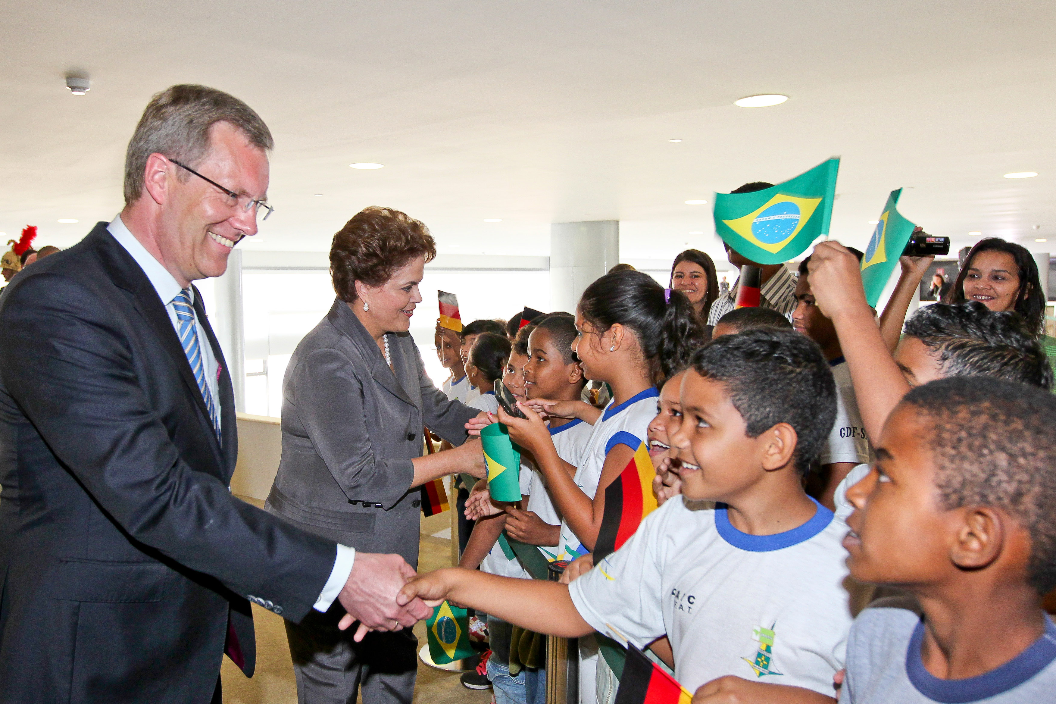 Presidenta Dilma Rousseff e o presidente da Alemanha, Christian Wulff, cumprimentam crianças na cerimônia oficial de chegada ao Brasil 2