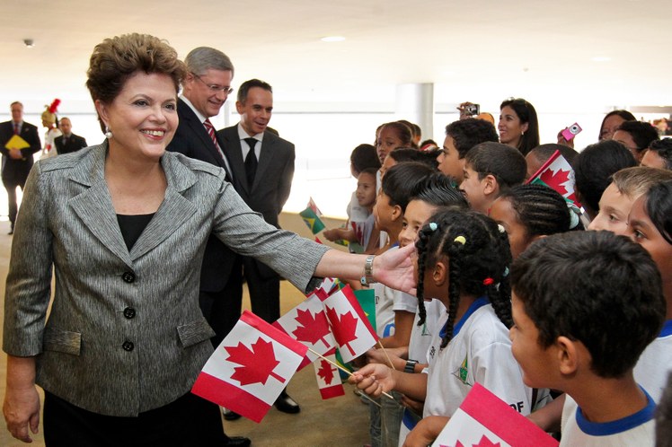 Dilma Rousseff e o primeiro-ministro do Canadá, Stephen Harper, cumprimentam crianças