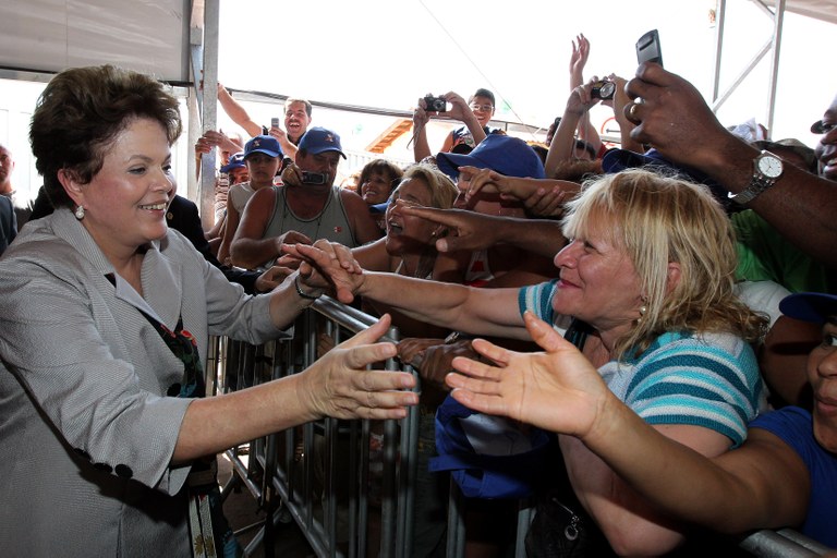 Presidenta Dilma Rousseff cumprimenta o público presente à cerimônia de entrega de unidades habitacionais do programa Minha Casa, Minha Vida.