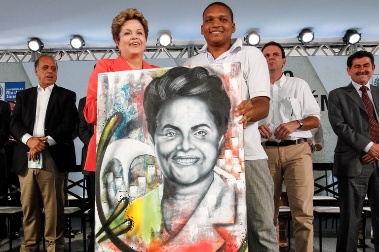 Presidenta Dilma Rousseff recebe presente do artista plástico Wark da Rocinha durante cerimônia de anúncio de investimentos em infraestrutura  urbana e equipamentos sociais nas comunidades da Rocinha e nos complexos do Lins e do Jacarezinho. Rio de Janeiro - RJ, 14/06/2013