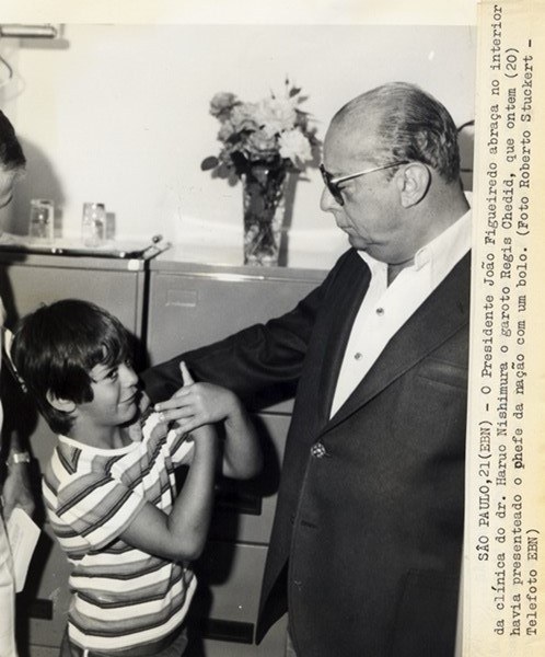 Presidente João Figueiredo abraça, na clínica do dr. Haruo Nishimura, o garoto Regis Chedid, que havia presenteado o chefe da nação com um bolo