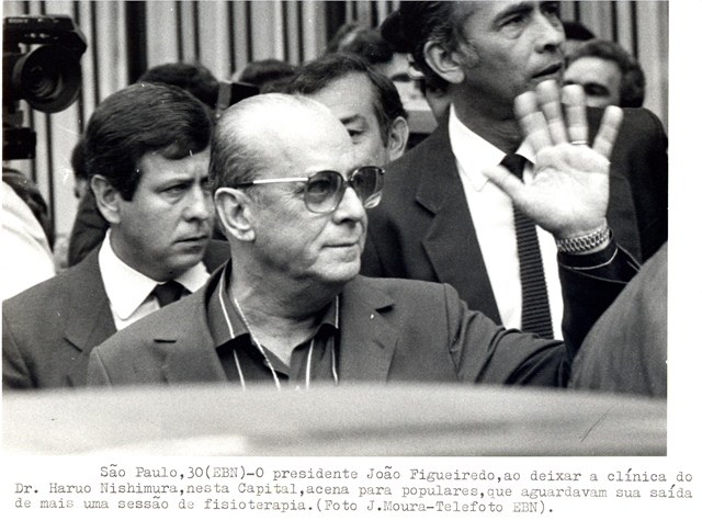 Presidente João Figueiredo, ao deixar a clínica do dr. Haruo Nishimura,  acena para populares