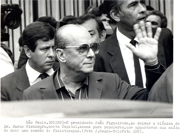 Presidente João Figueiredo, ao deixar a clínica do dr. Haruo Nishimura,  acena para populares