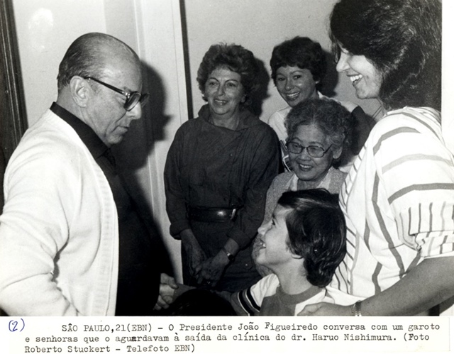 Presidente João Figueiredo conversa com um garoto e senhoras que o aguardavam à saída da clínica do dr. Haruo Nishimura