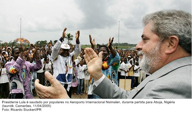 Presidente Lula é saudado por populares no aeroporto internacional de Nsimalen durante partida para Abuja, Nigéria.