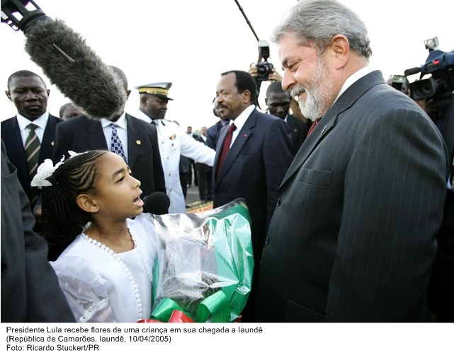 Presidente Lula recebe flores de uma criança em sua chegada a Laundê.