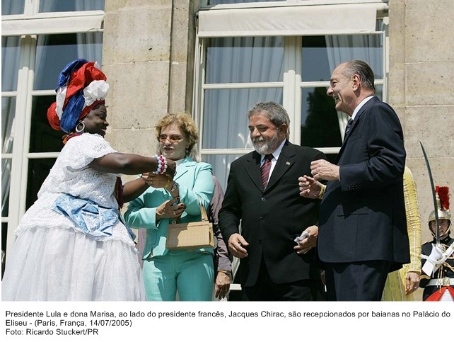 Presidente Lula, dona Marisa e o presidente francês, Jacques Chirac, são recepcionados por baianas no Palácio do Eliseu.