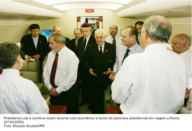 Presidente Lula e comitiva rezam durante culto ecumênico a bordo da aeronave presidencial em viagem a Roma.