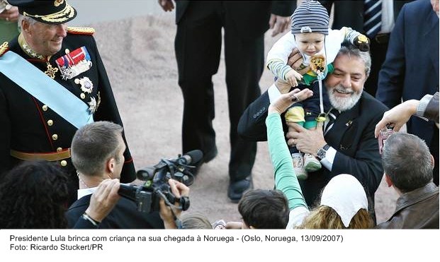 Presidente Lula brinca com criança na sua chegada à Noruega.