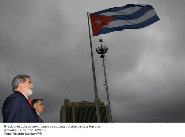 Presidente Lula observa a bandeira cubana em visita a Havana.