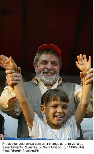 Presidente Lula brinca com uma criança durante visita ao Assentamento Palmares