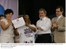 Presidente Lula, ao lado da min. da SEPM, Nilcéa Freire (E), e do ministro da Saúde, Agenor Álvares, entrega certificado à voluntária no tratamento da Aids.