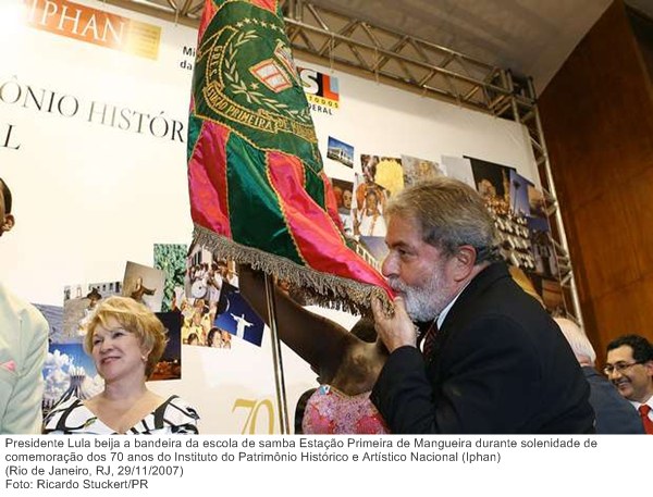 Presidente Lula beija a bandeira da escola de samba Estação Primeira de Mangueira durante solenidade de comemoração dos 70 anos do Iphan.