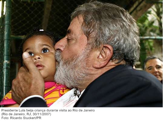 Presidente Lula beija criança durante visita ao Rio de Janeiro.