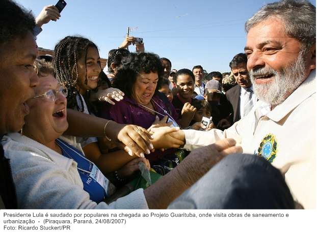Presidente Lula é saudado por populares na chegada ao Projeto Guarituba, onde visita obras de saneamento e urbanização.
