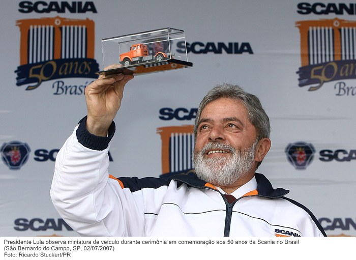 Presidente Lula observa miniatura de veículo durante cerimônia em comemoração aos 50 anos da Scania no Brasil.