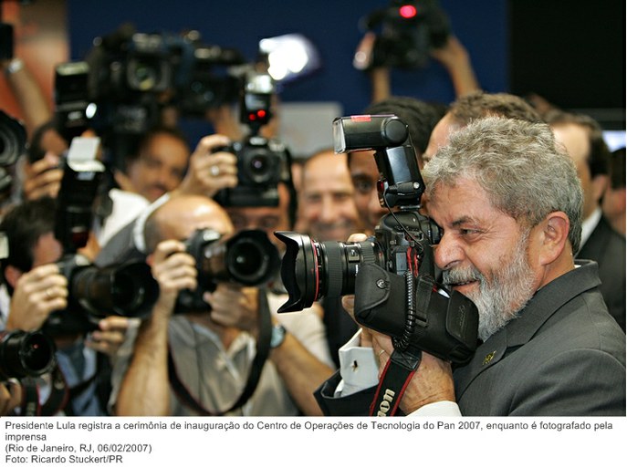 Presidente Lula registra a cerimônia de inauguração do Centro de Operações de Tecnologia do Pan 2007, enquanto é fotografado pela imprensa.