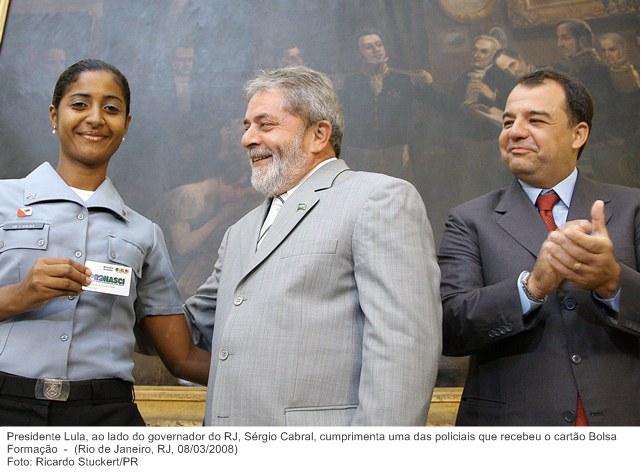 Presidente Lula, ao lado do governador do RJ, Sérgio Cabral, cumprimenta uma das policiais que recebeu o cartão Bolsa Formação.