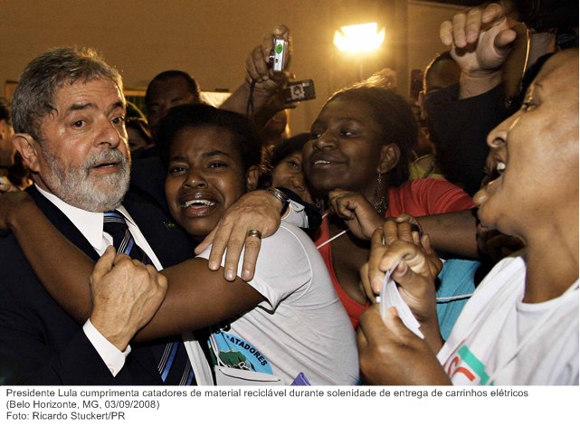 Presidente Lula cumprimenta catadores de material reciclável durante solenidade de entrega de carrinhos elétricos.