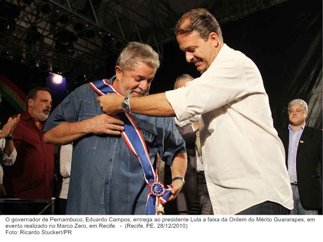 O governador de Pernambuco, Eduardo Campos, entrega ao presidente Lula a faixa da Ordem do Mérito Guararapes, em evento realizado no Marco Zero, em Recife.